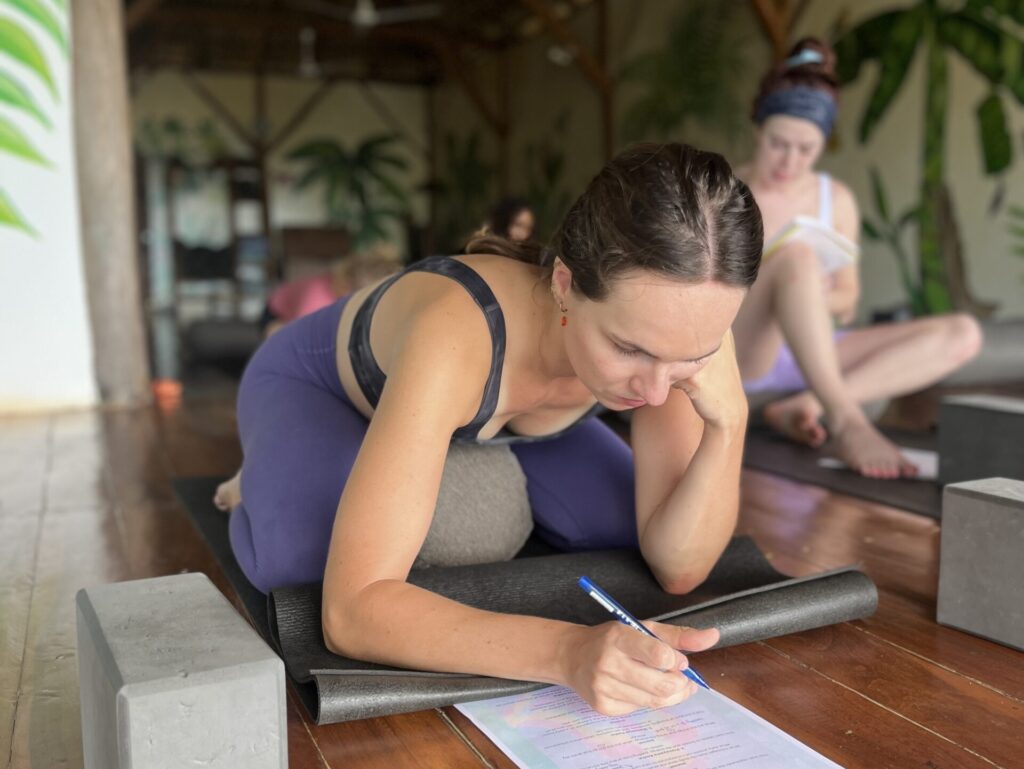 Yoga teacher training participants studying during a workshop, focusing on learning and deepening their practice in Central America